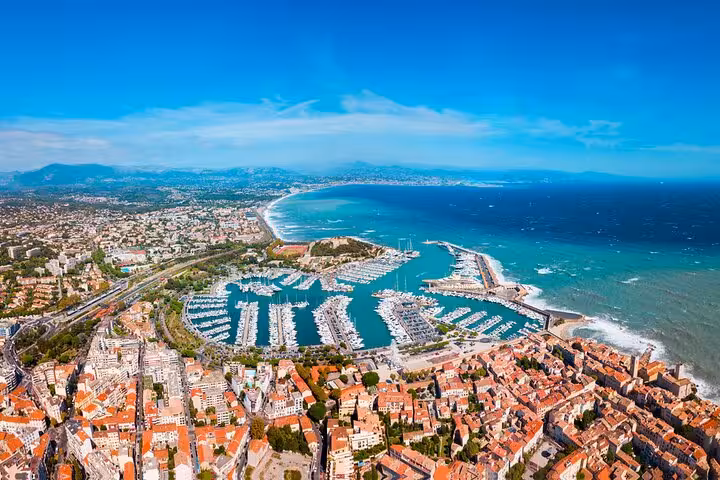 Aerial view of Cannes marina and Mediterranean coastline with turquoise water and red-roofed buildings