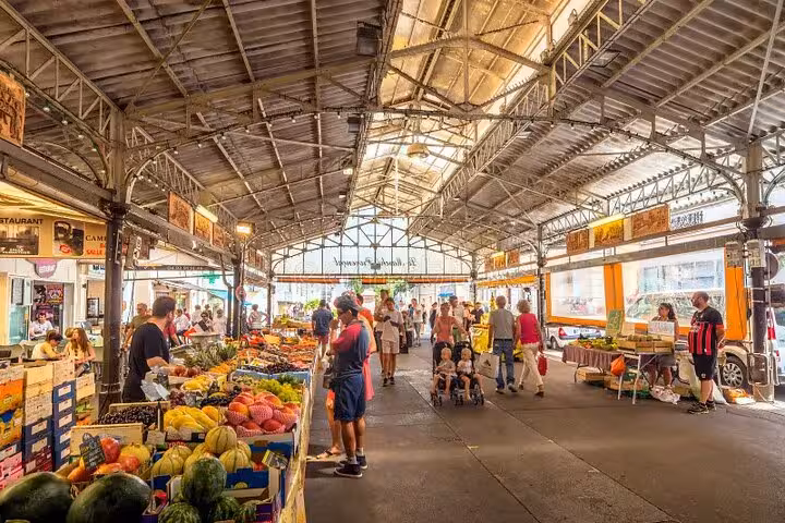 Busy indoor market hall with fresh fruit and vegetable stalls and shoppers in Cannes, French Riviera