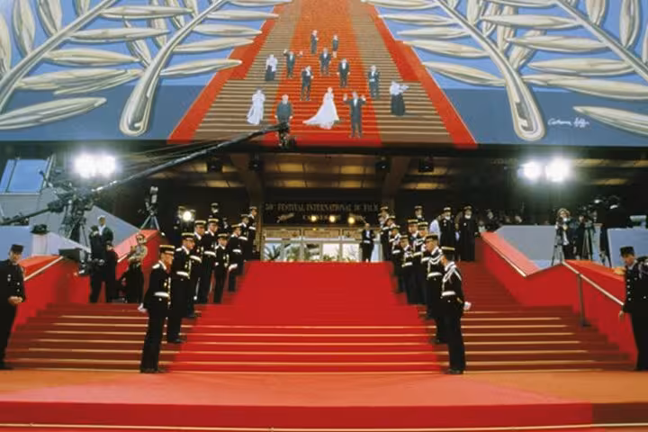 Red carpet staircase at Cannes Film Festival Palais with uniformed guards lining the steps