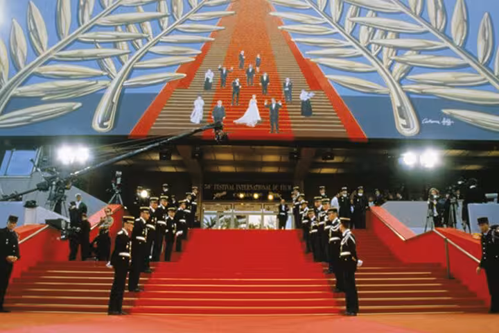 Red carpet stairs at Cannes Film Festival Palace with uniformed guards lining the steps