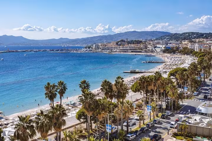 Stunning aerial view of Cannes beach with turquoise waters, palm trees, and Golden Coast on a private day trip