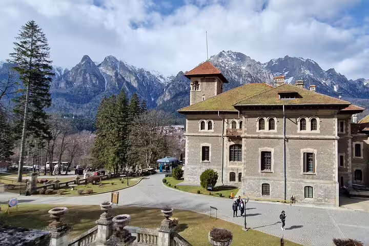 Cantacuzino Castle with snow-capped Bucegi Mountains backdrop near Brasov, Romania