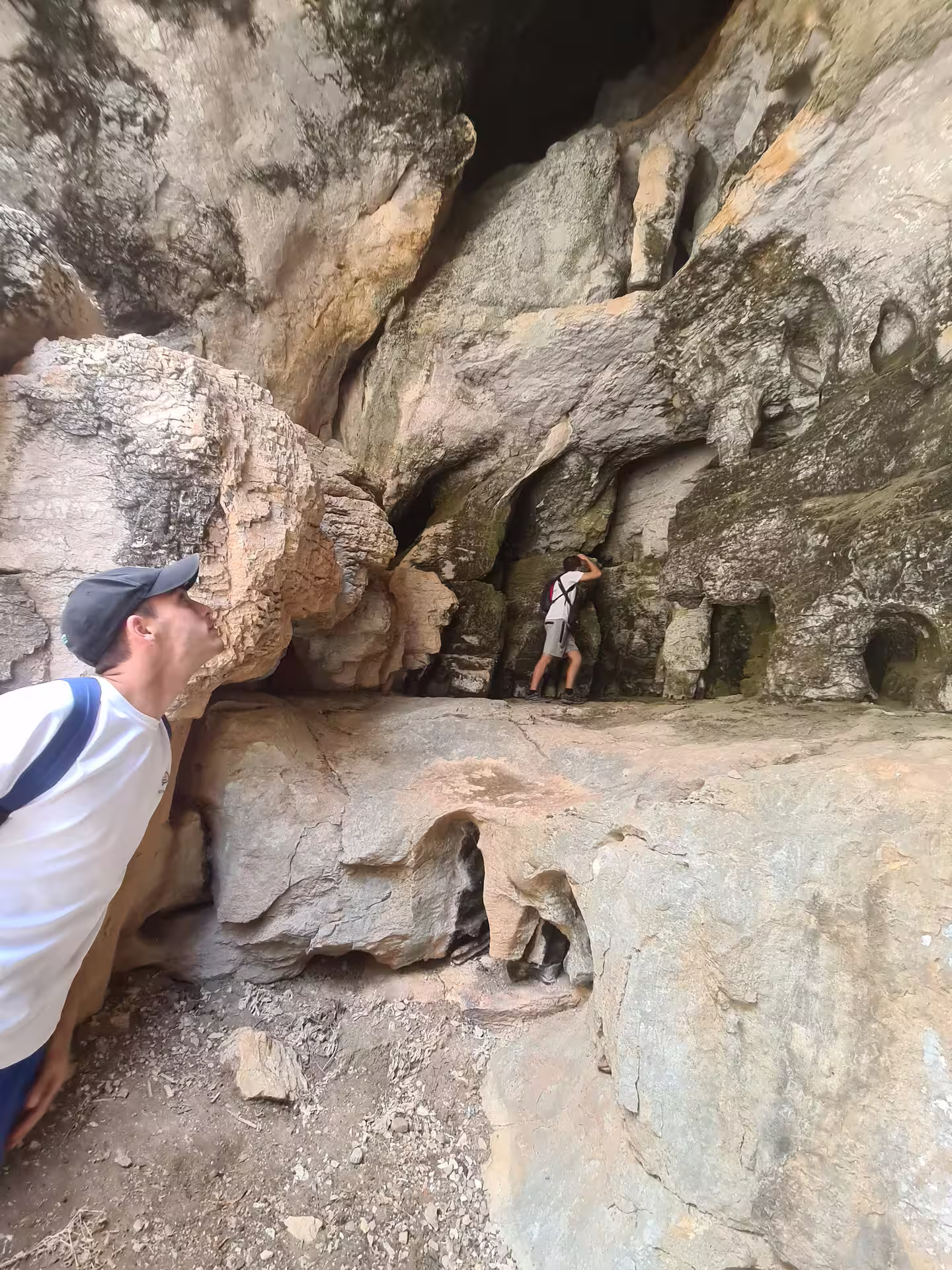Explorers examining the intricate rock formations inside a cave at Canuto de la Utrera hiking site.