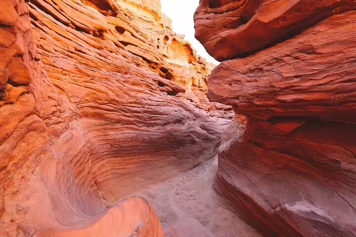 Narrow red sandstone passage in Canyon Salama on Jeep safari tour from Sharm el Sheikh to Dahab