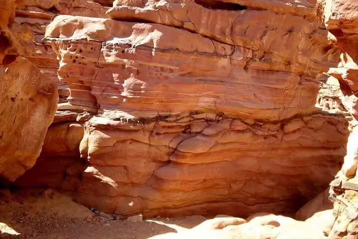 Layered red sandstone wall in Canyon Salama on the Sharm el Sheikh Jeep safari to Dahab day trip