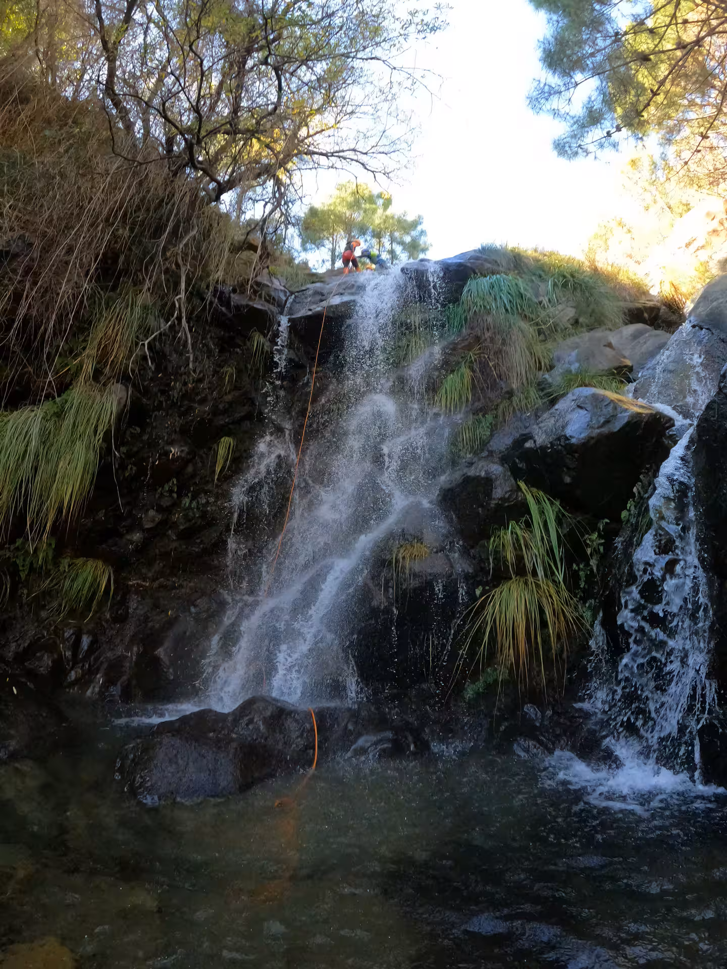 Adventure seeker abseiling down a stunning waterfall on a guided canyoning tour in Sierra Bermeja, Estepona Spain