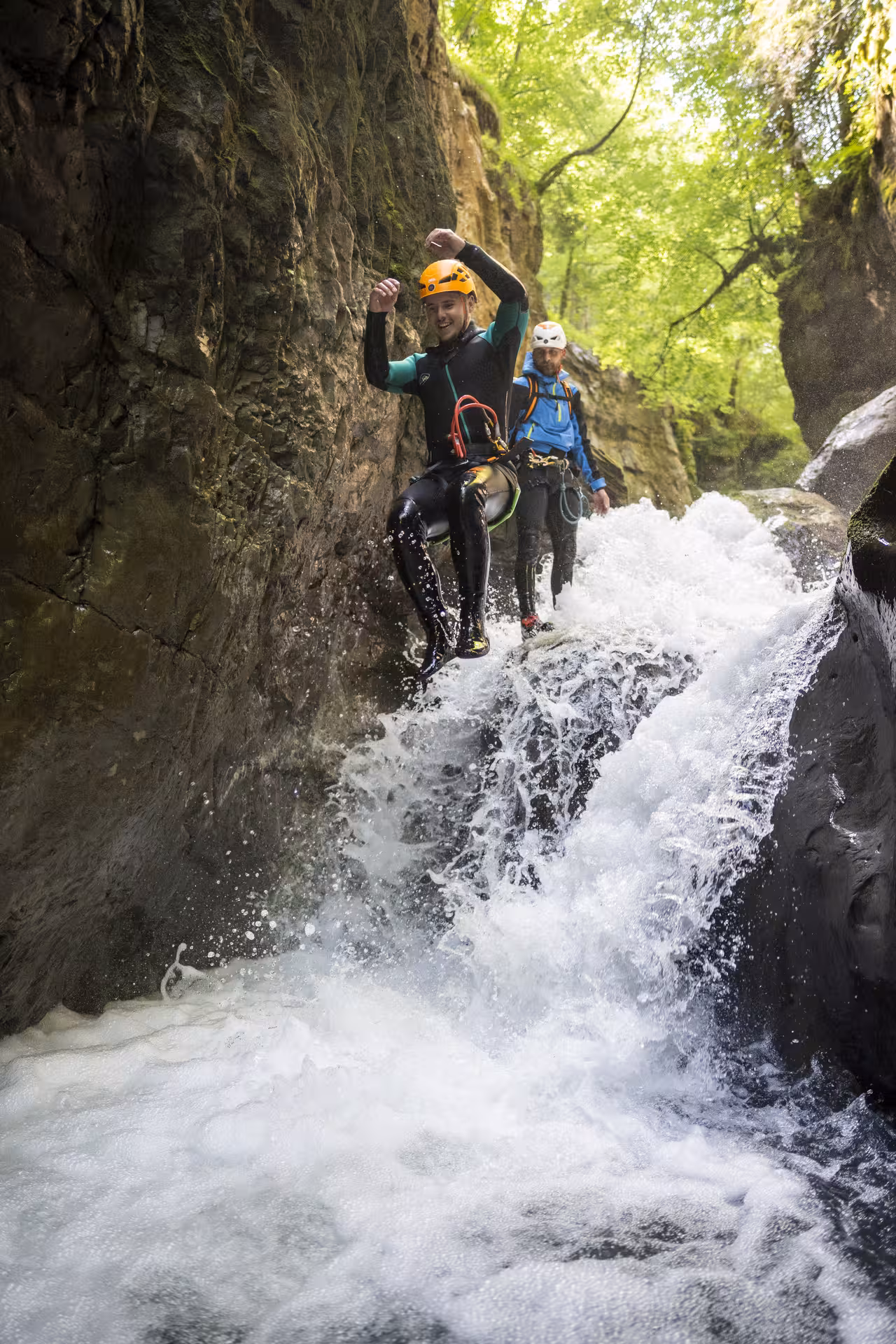 Adventurers enjoy thrilling jump into waterfall during Canyoning Interlaken experience, surrounded by lush nature.