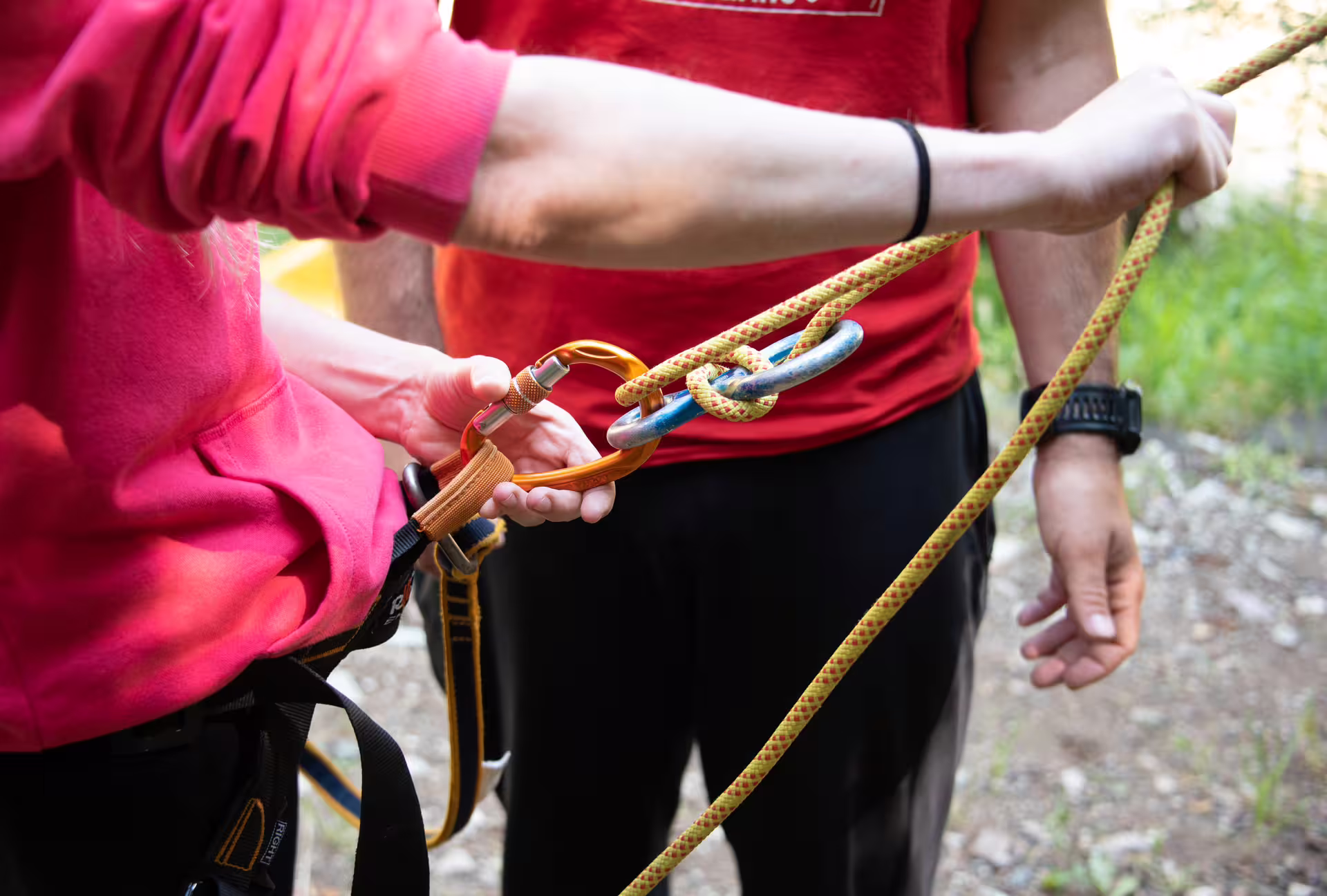 Guide checks carabiner and safety rope before rappelling on Canyoning Neda Waterfalls adventure in Galicia