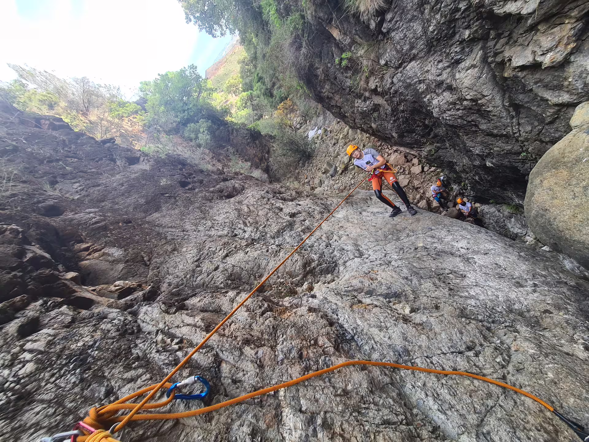 Adventurers rappelling down rugged cliffs during a canyoning tour in Sierra Bermeja, Estepona's wild nature.