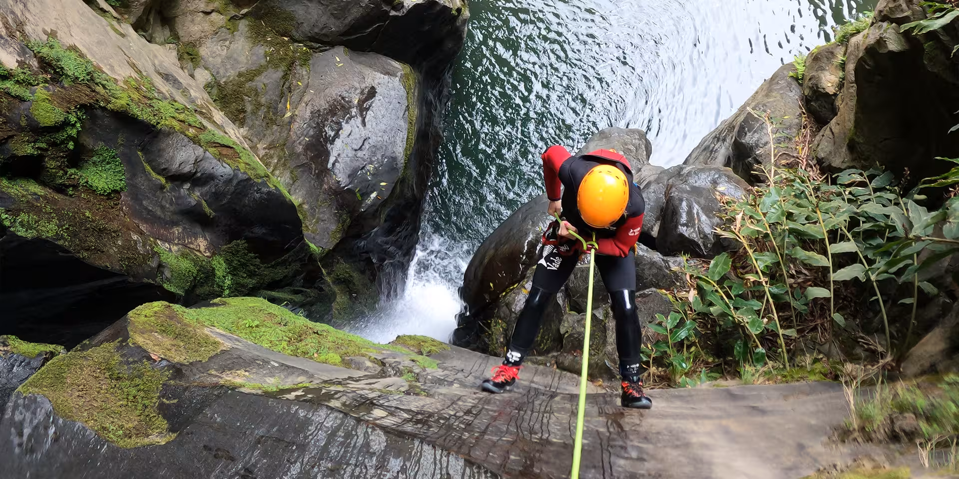 Canyoning at Salto do Cabrito: participant rappelling toward a deep gorge pool on São Miguel, Azores