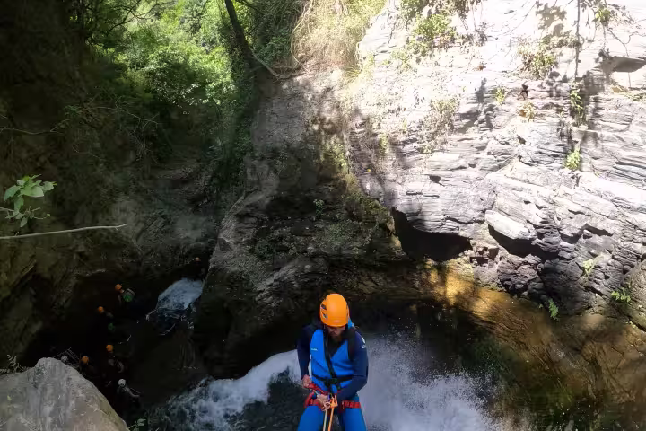 A guide rappels down a stunning waterfall during the Canyoning Sima del Diablo guided tour in Ronda Spain
