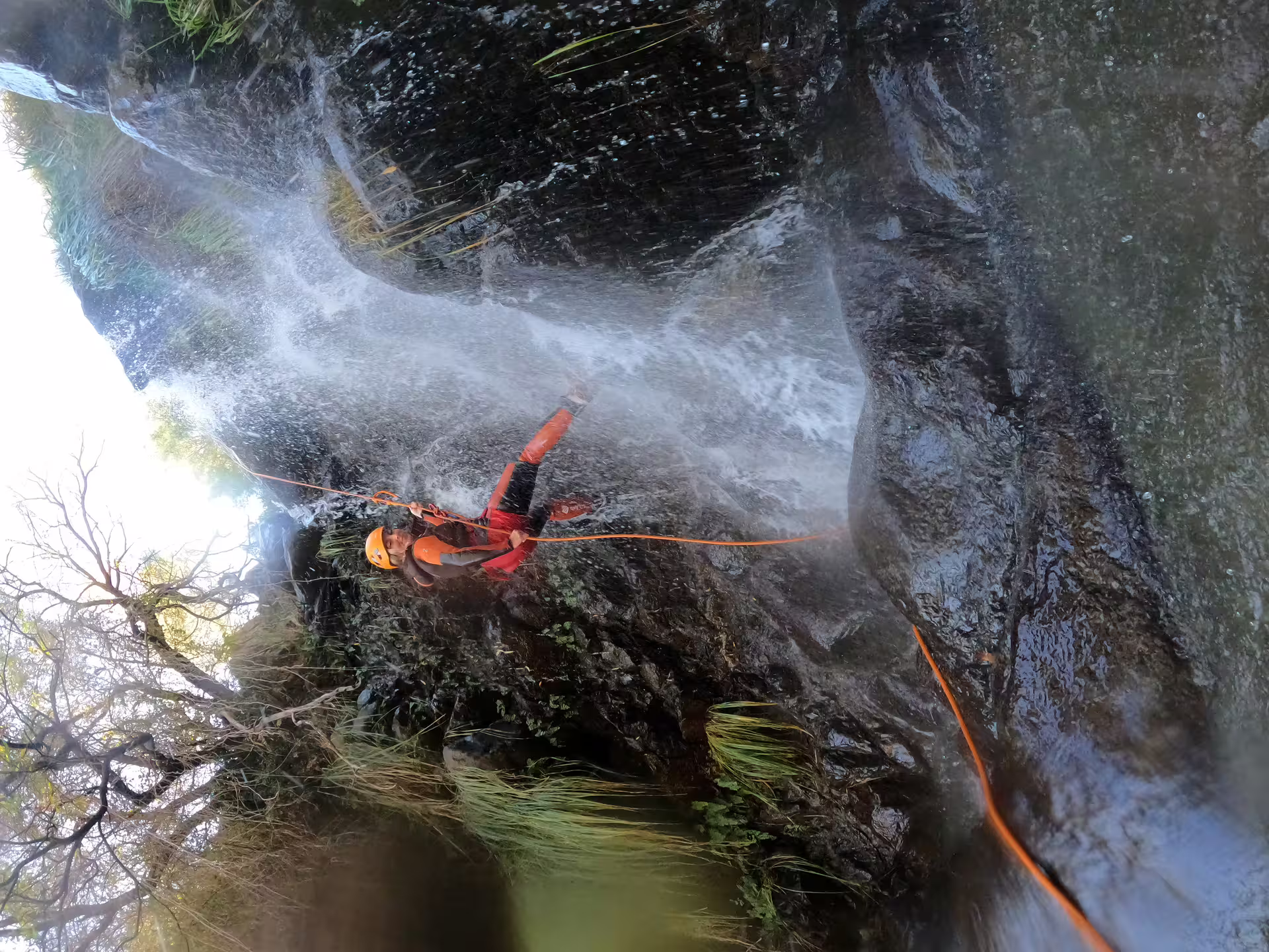 Thrill-seeker navigates a cascading waterfall during a canyoning adventure in the rugged Sierra Bermeja, Estepona.