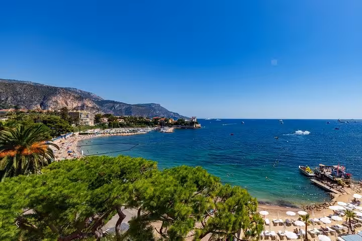 Panoramic view of Cap Ferrat bay with turquoise waters, sandy beach, and Mediterranean coastline near Nice