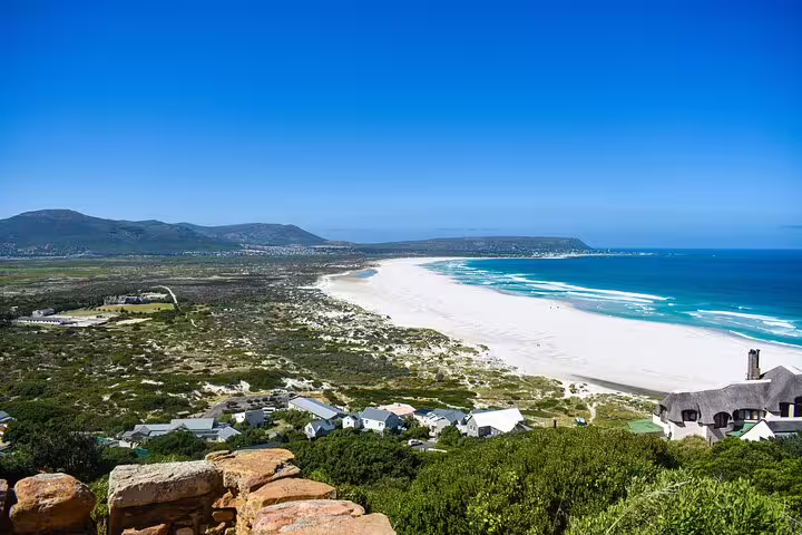 Scenic view of the Cape of Good Hope's coastline with white sandy beaches and turquoise waters, ideal for a full-day tour.