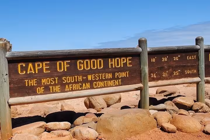 Signboard marking the Cape of Good Hope, the most southwestern point of the African continent, surrounded by rocks.