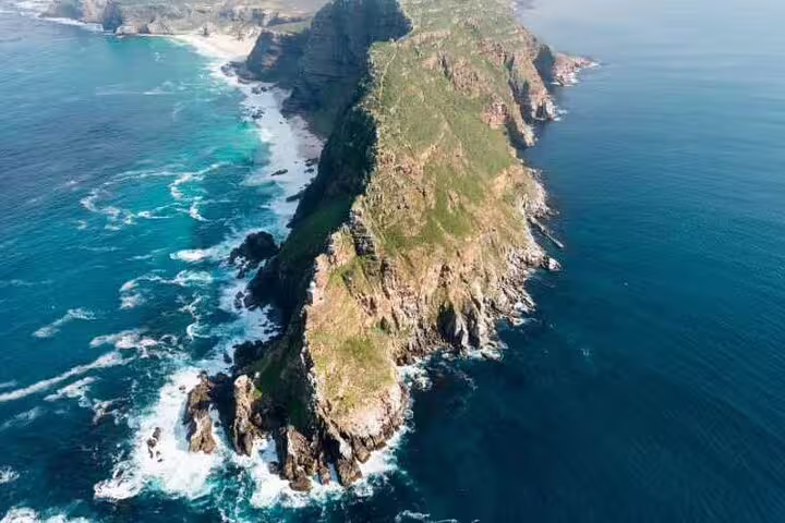Aerial view of Cape Point's rugged cliffs and turquoise waters along the Garden Route in South Africa.