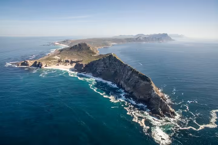 Aerial view of Cape Point's rugged coastline surrounded by azure waters in Cape Town, perfect for scenic tours.