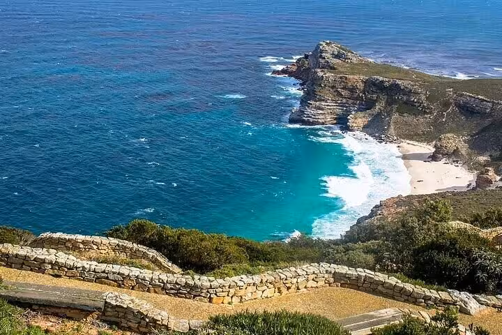 Breathtaking coastline at Cape Point with turquoise waters and sandy beach, highlighting South Africa's natural beauty.