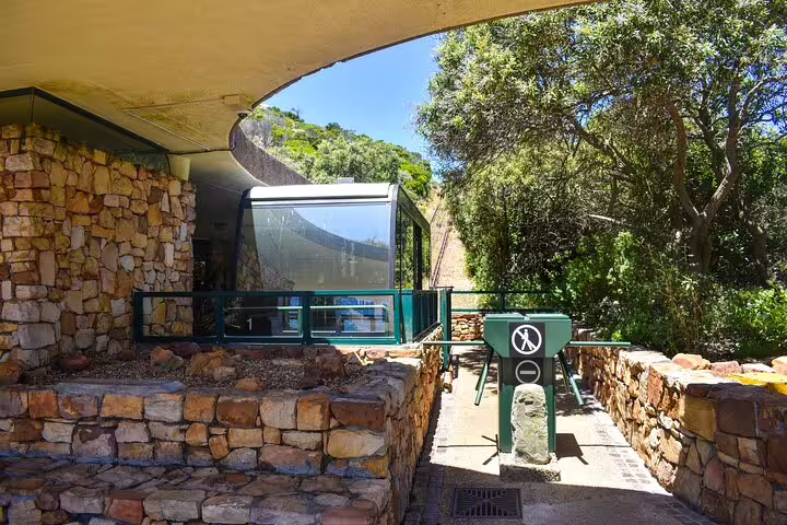 Entrance to the Flying Dutchman Funicular at Cape Point, surrounded by stone walls and lush greenery.