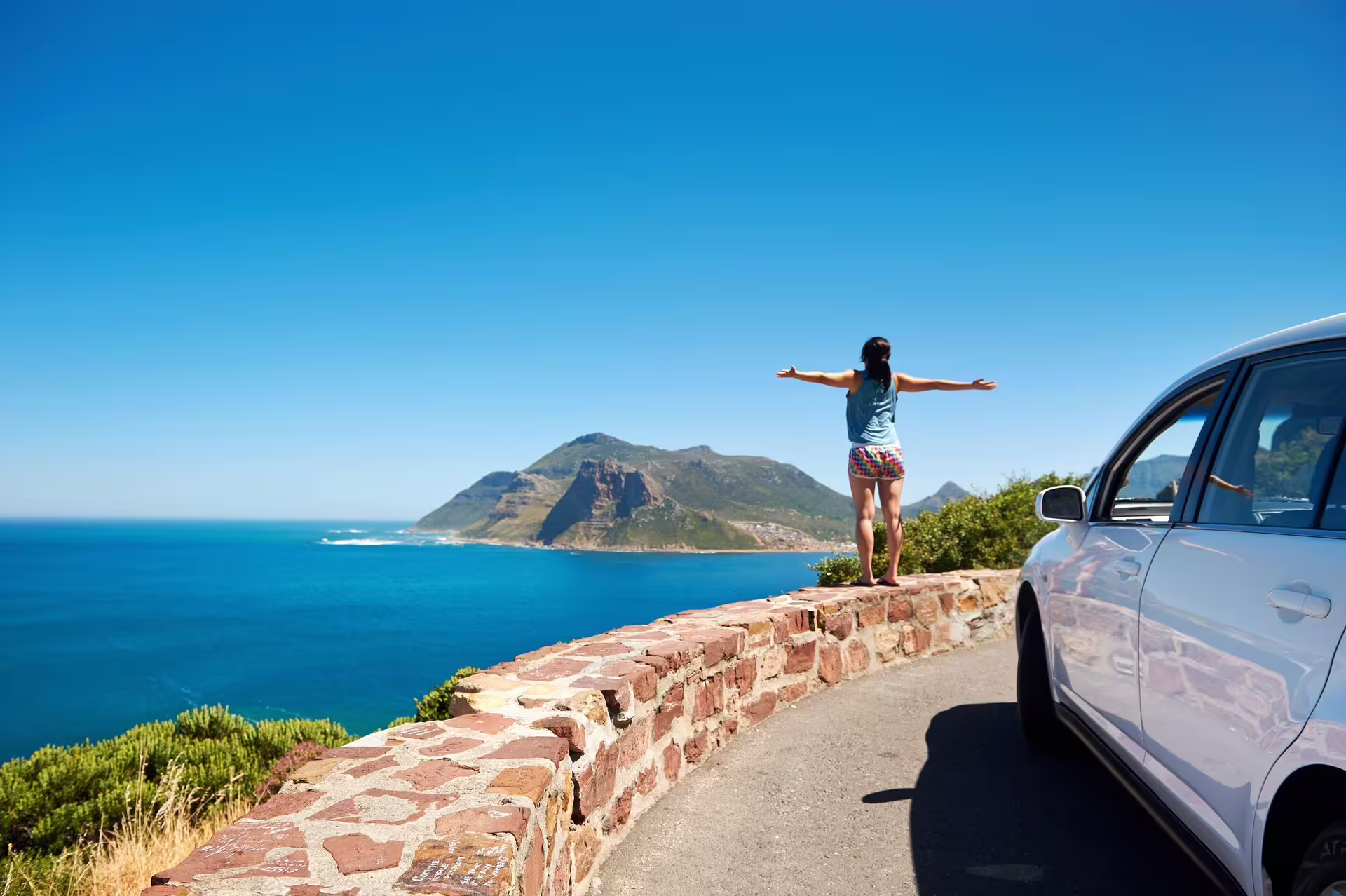 Traveler enjoying the stunning coastline view from a scenic spot on the Cape Point tour route.