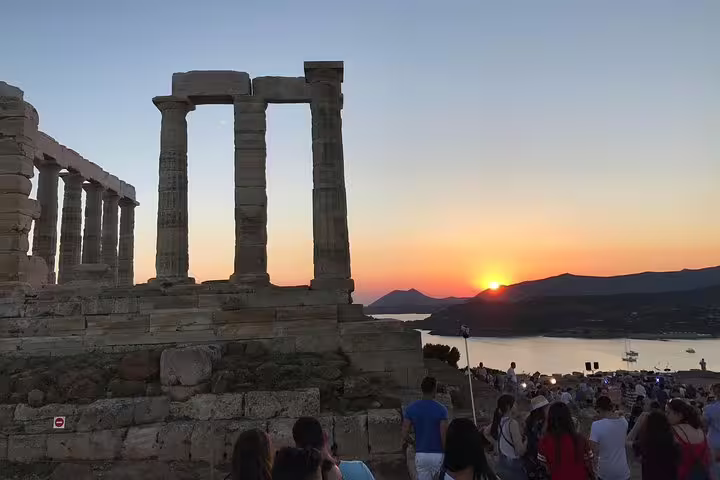 Sunset at Cape Sounion Temple of Poseidon with visitors on Athens half-day small-group tour
