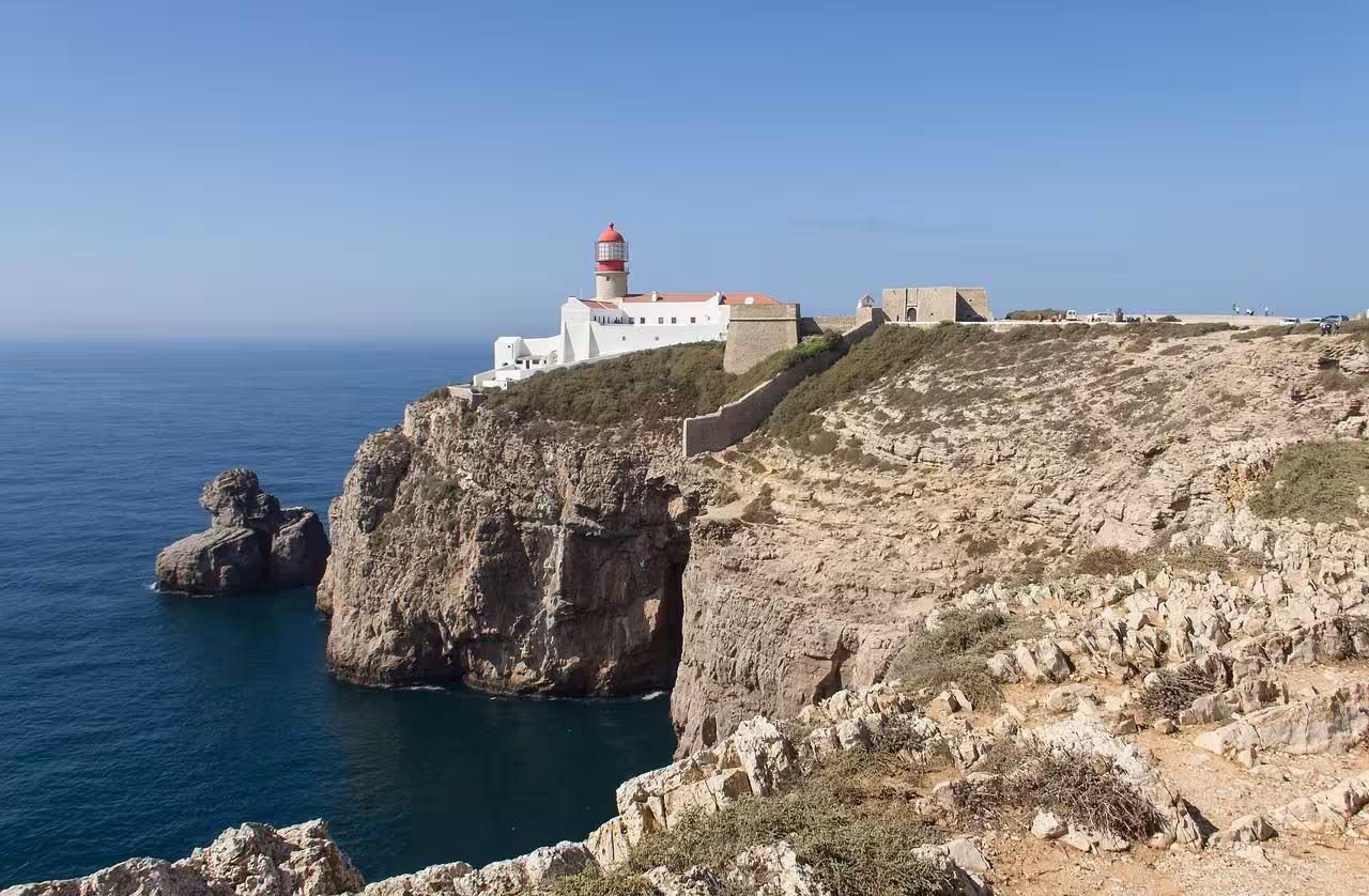 Iconic Cape St. Vincent lighthouse perched on towering Algarve cliffs above deep blue Atlantic Ocean on Algarve à la Carte route