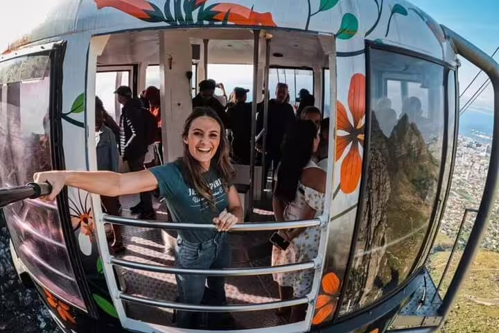 Tourists enjoying a scenic ride in the Cape Town cable car with stunning views, part of the historical walking tour.