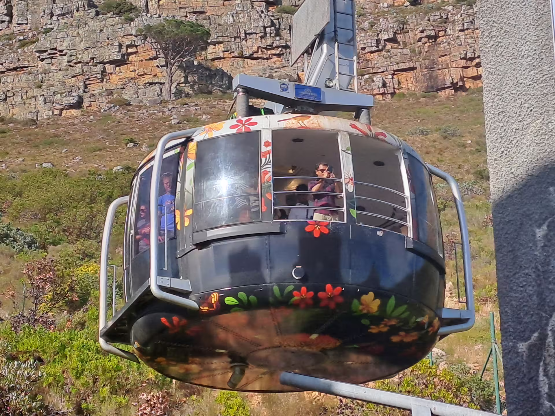Colorful cable car ascending Table Mountain, offering panoramic views of Cape Town's scenic landscapes.