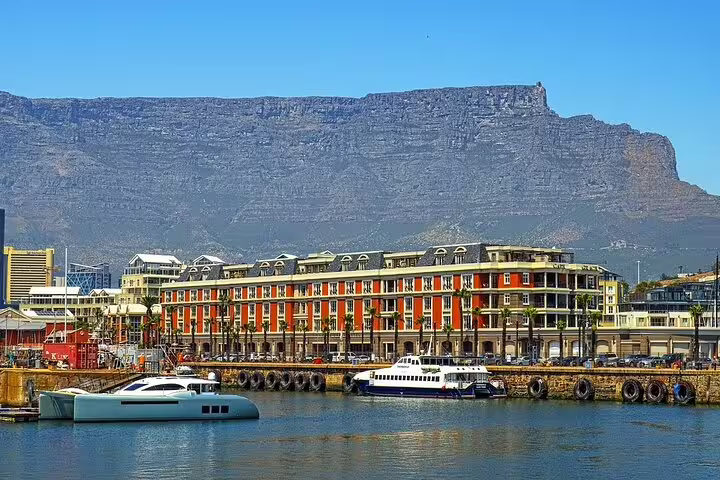 Scenic view of Cape Town waterfront with Table Mountain backdrop, ideal for cable car adventure seekers.