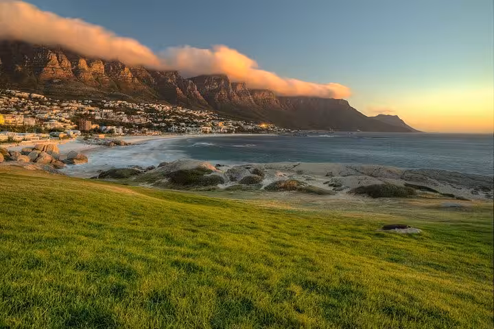 Scenic view of Cape Town's Table Mountain and coastline at sunset, ideal for private city tour and wine tasting.
