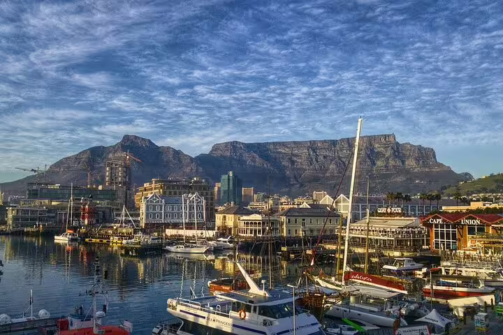 Scenic view of Cape Town's V&A Waterfront with Table Mountain backdrop, ideal for shopping and private chauffeur tours.