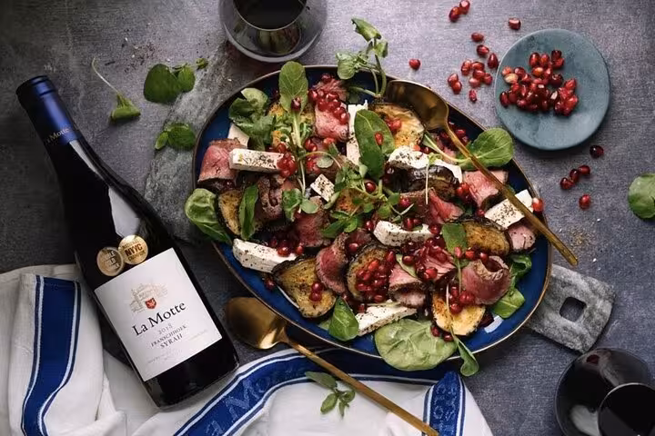 Gourmet salad paired with La Motte wine, showcasing culinary delights on Cape Town's winelands tour.