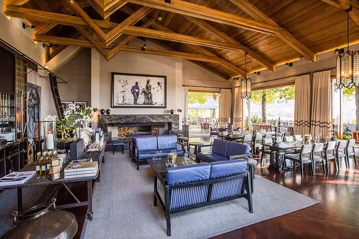 Luxurious Cape Town winery interior with elegant seating and scenic vineyard views.