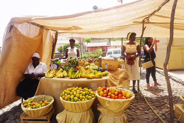 Local Cape Verdean market stall with fresh fruits and smiling vendors offering authentic cultural experiences.