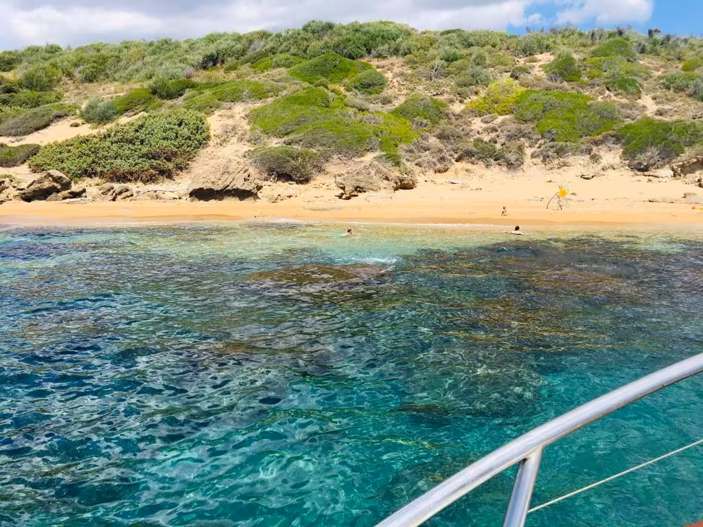 Pristine turquoise waters and sandy beach of Capo Rizzuto, ideal for snorkeling and exploration on the boat tour.