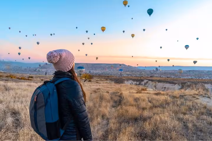Traveler watching Cappadocia balloon-filled sunrise sky, unforgettable experience on 8 day Mediterranean tour