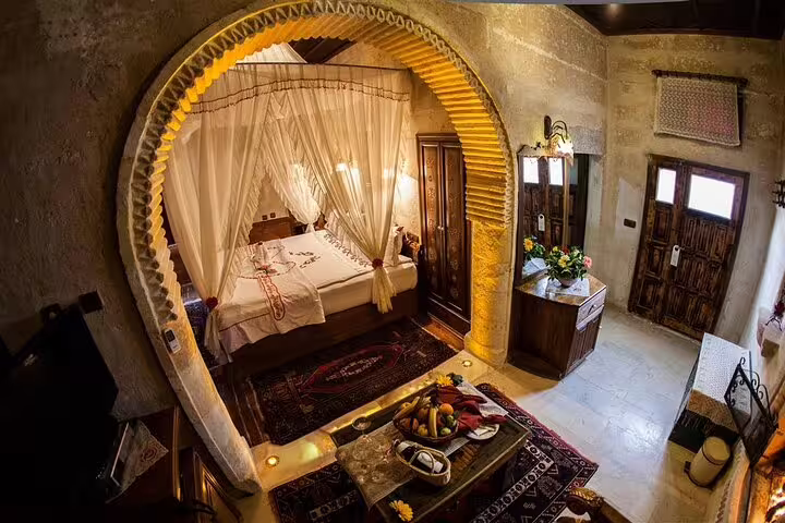 Traditional Cappadocia cave hotel room with arched bed alcove, overnight stay on 2 day 1 night tour from Istanbul