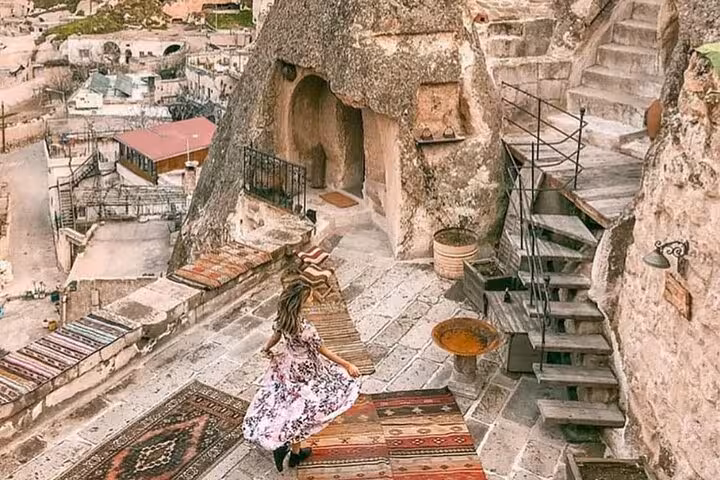 Traveler on rug-lined terrace at Cappadocia cave house, a highlight of the 2-day North and South tour