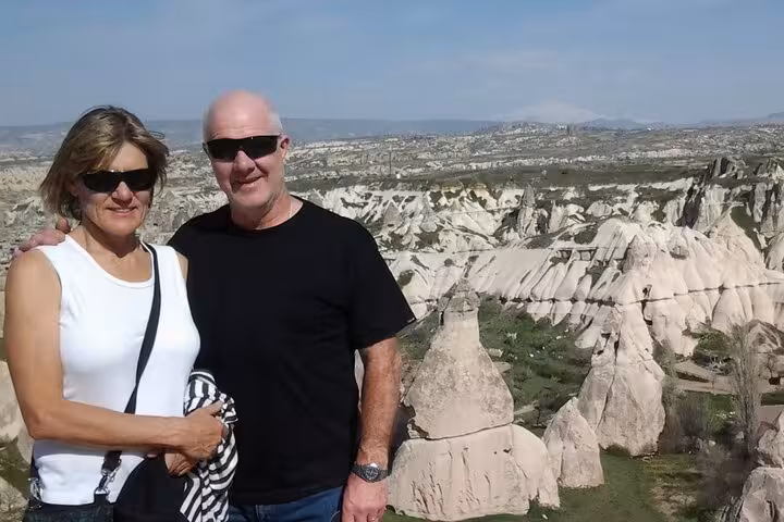 Couple at Cappadocia panoramic viewpoint overlooking fairy chimneys on North Tour before Turkish hamam