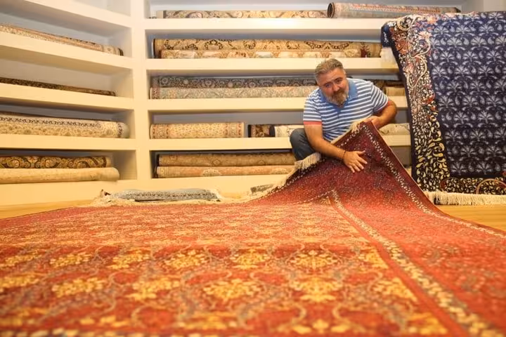 Cappadocia shopping tour at a Turkish carpet shop, vendor showing handmade Anatolian rug patterns
