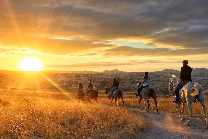 Riders on a Cappadocia sunset horseback riding tour, 2-hour guided trail with golden light and valleys