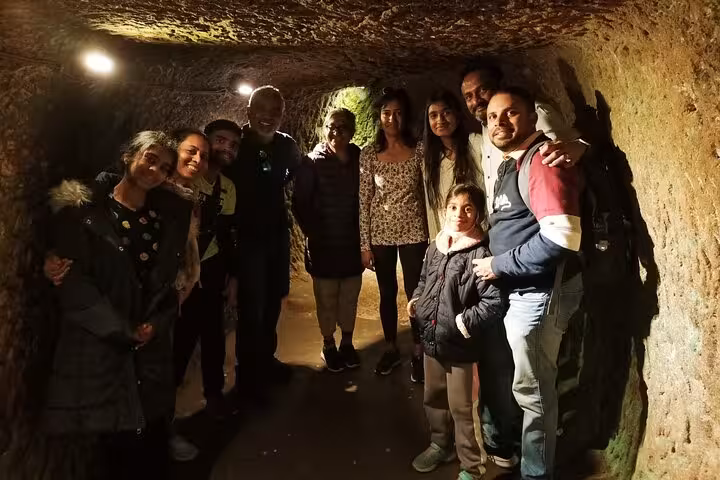 Group exploring Cappadocia underground city tunnel on a 1-day guided tour with private vehicle service