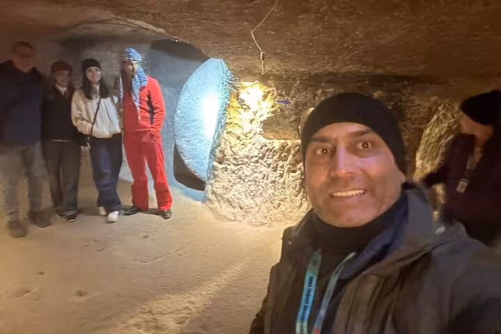 Travelers inside Cappadocia underground city tunnel with guide on small group tour including lunch and transfers