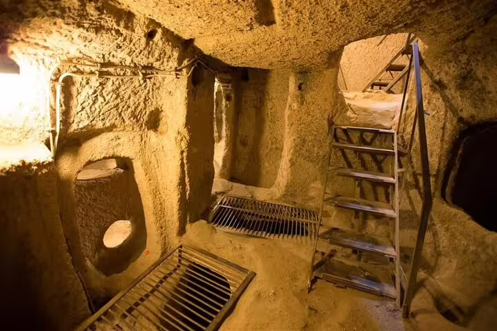 Inside view of Cappadocia's underground city with intricate tunnels and staircases, showcasing historical architecture.