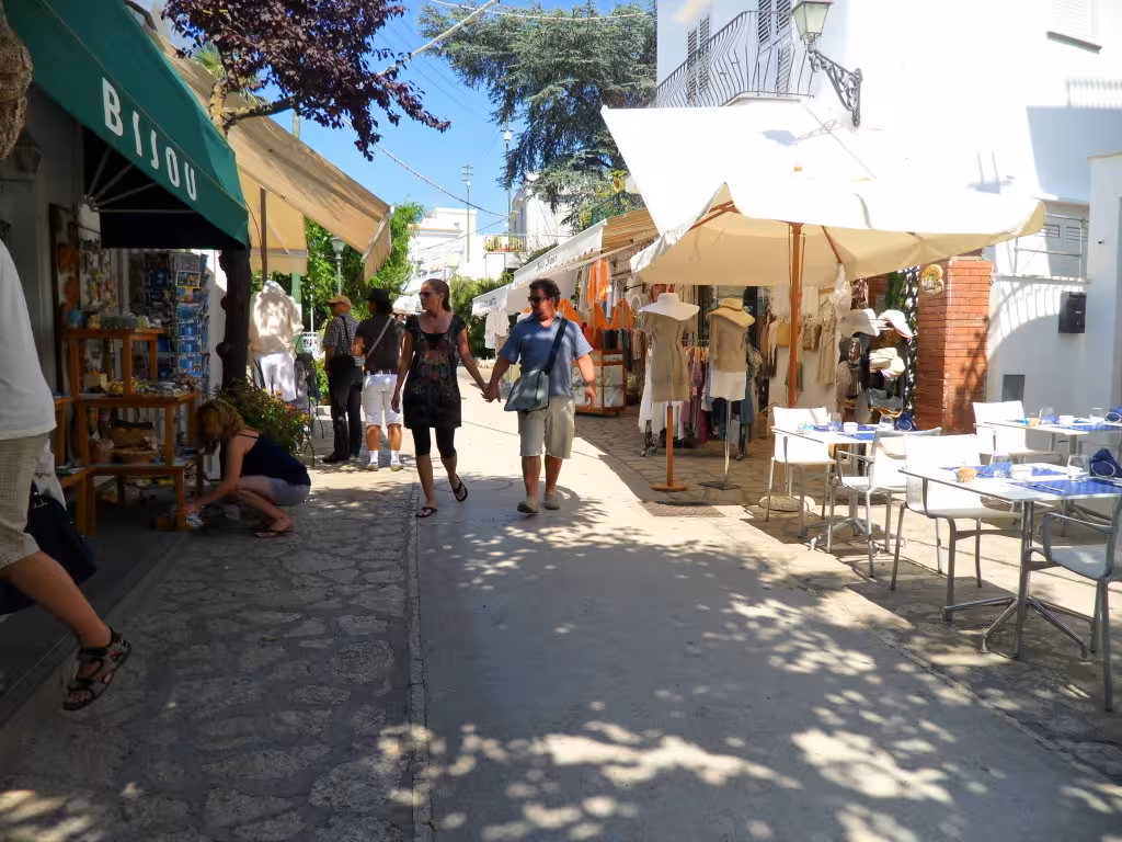 Visitors stroll through a charming street market in Capri, showcasing local crafts and boutiques on the Capri & Anacapri tour.