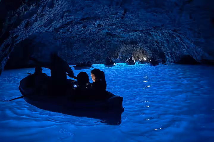 Experience the enchanting glow of the Blue Grotto on Capri with a serene boat excursion from Naples.