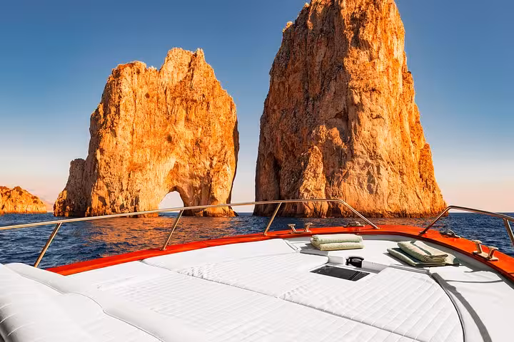 Luxurious boat deck facing the iconic Faraglioni rock formations during a Capri excursion from Sorrento.