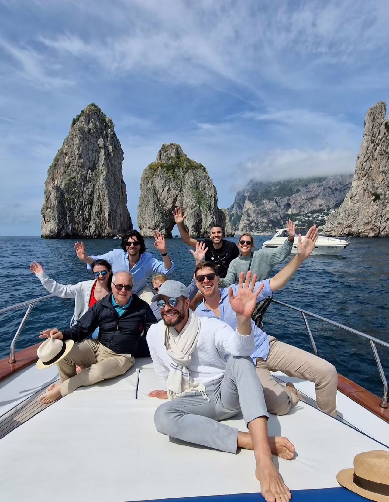 Group enjoying a private boat tour near Capri's iconic Faraglioni rock formations, perfect for seaside relaxation.
