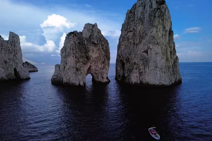 Private full-day boat tour by Capri Faraglioni rocks, sea arch and deep blue water for sightseeing and photos