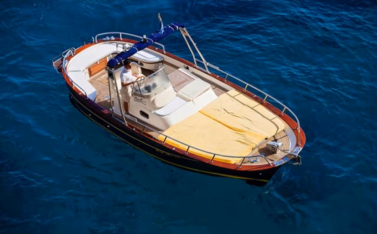 Capri sightseeing boat with skipper on crystal-clear water, part of a best of Capri one-day boat experience